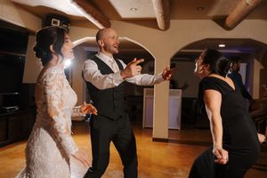 Dancers perform elegant spins and twirls across a wooden dance floor during a formal ballroom dance event.