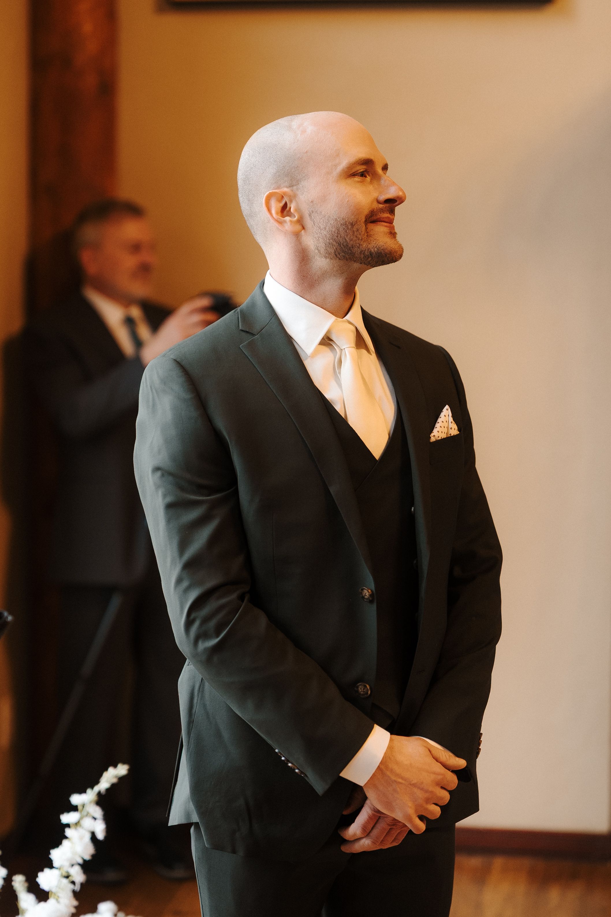 Groom's emotional reaction during first look moment at indoor wedding ceremony.