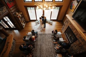 A cozy coffee shop interior with wooden beams, warm lighting, and customers seated at tables.