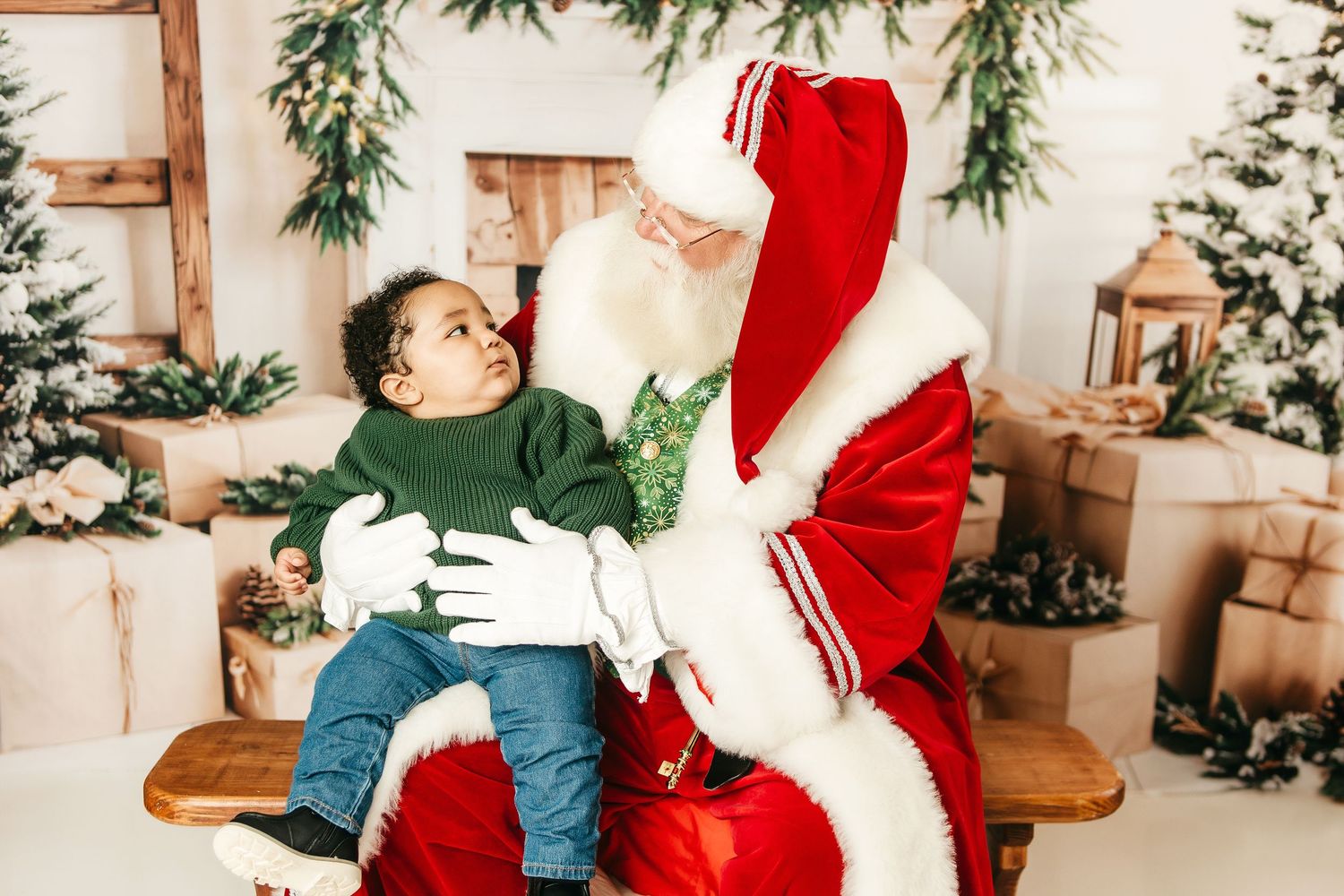 A festive holiday scene shows someone in a red Santa suit and another person sharing a sweet moment near a Christmas tree.