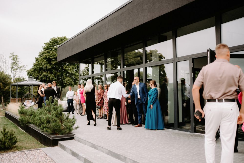 Contemporary wedding venue exterior with guests arriving for the ceremony.