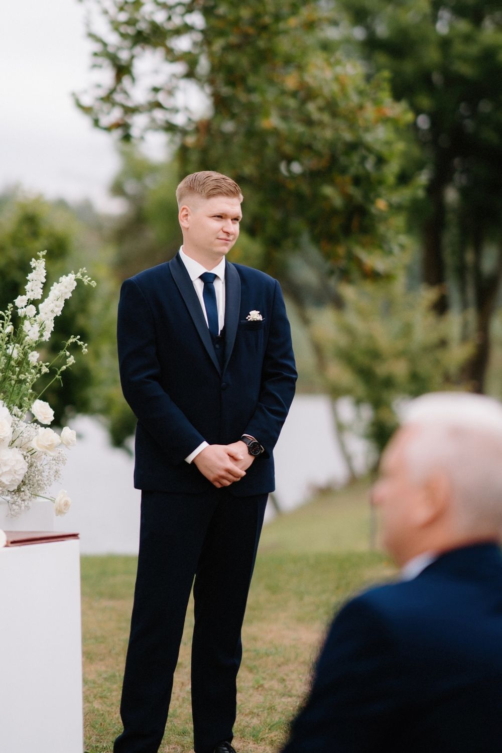 Formal wedding ceremony setup with attendants in dark suits.