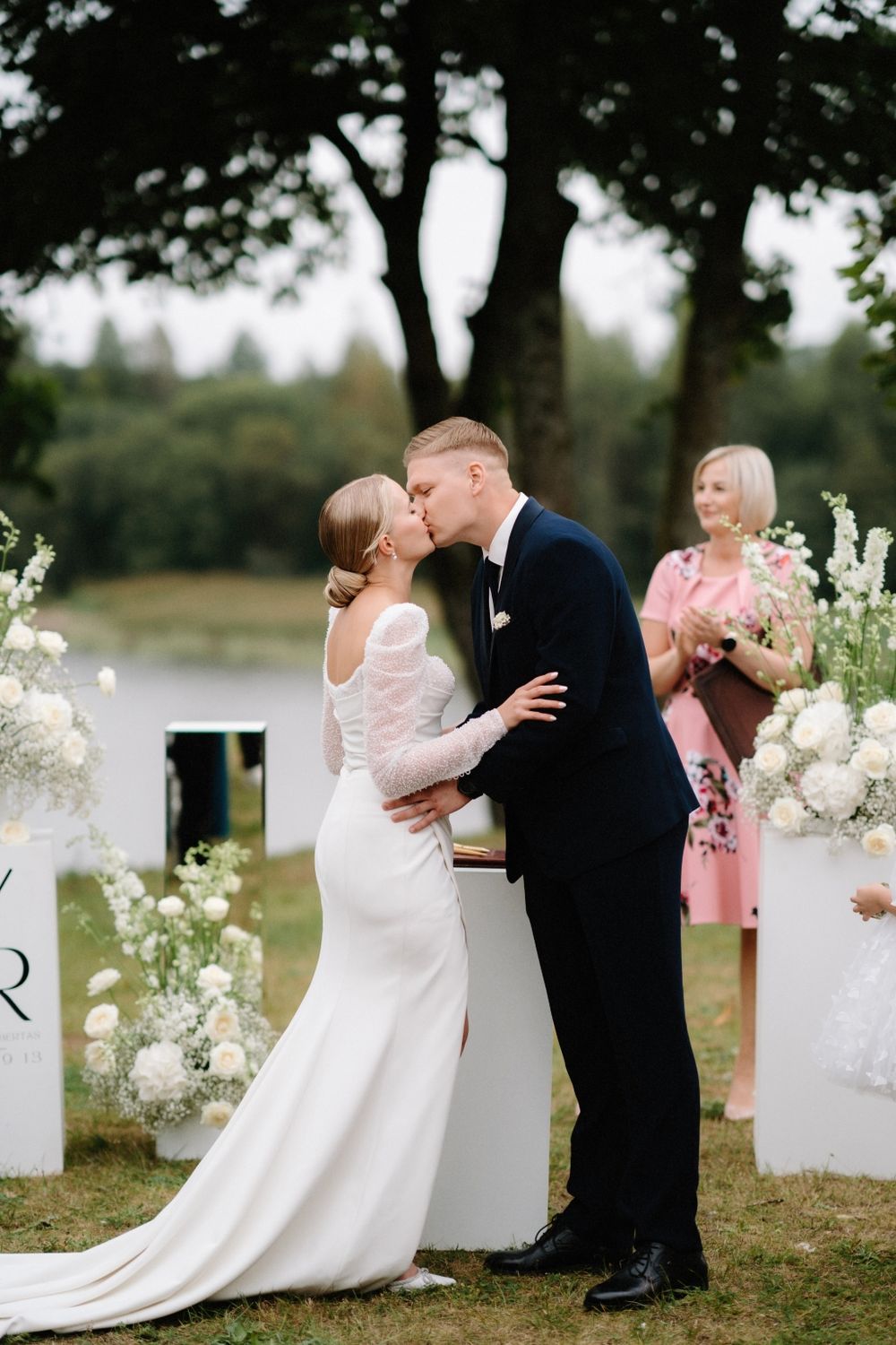 Romantic wedding moments captured between white monogram signs with floral decorations.