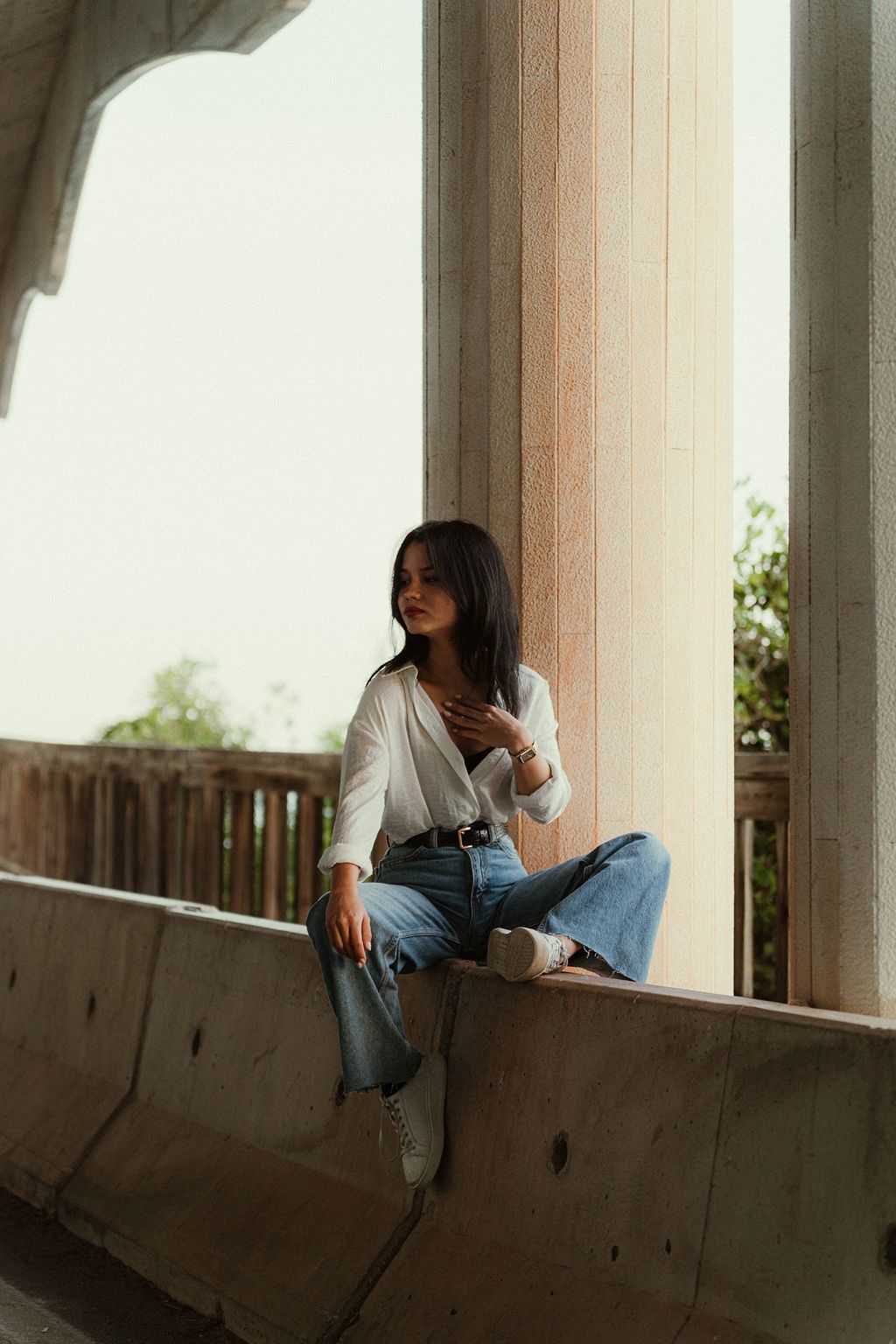 Artistic lifestyle portrait in a minimalist architectural setting with natural lighting.