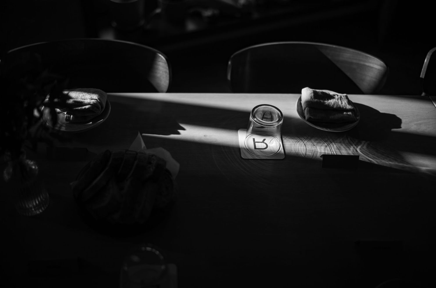 A dramatic black and white photo of a vintage aircraft in shadows.