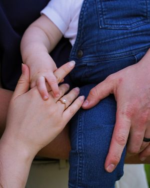 Close-up of hands with ring against denim background.