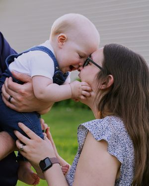 Sweet moment of affection shared between family members on a sunny day in the yard.