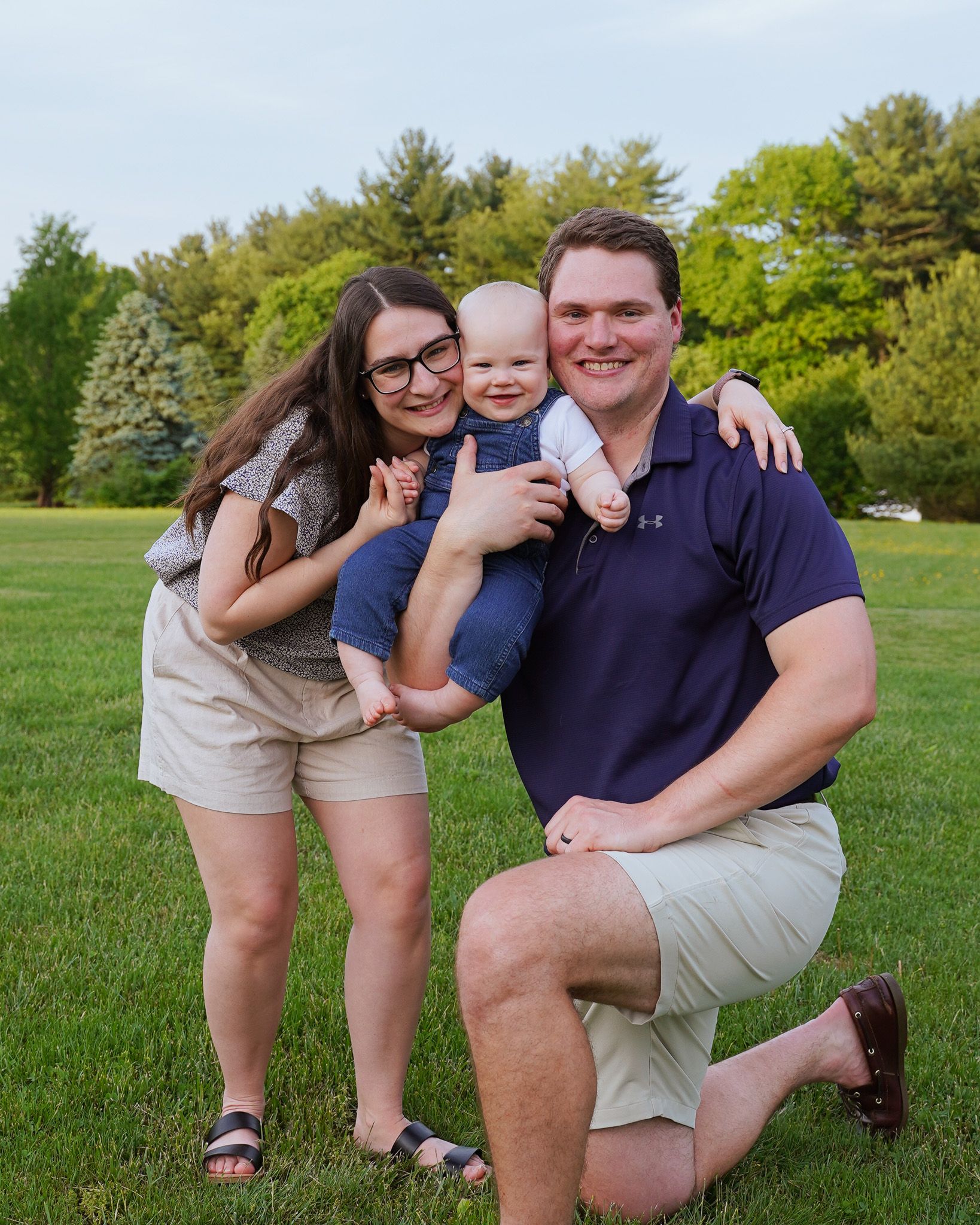 Family having fun together while posing for a photo on their green lawn.