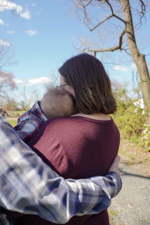 Intimate embrace against natural outdoor setting on a sunny day.