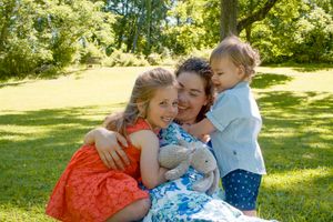 A joyful moment shared on a sunny lawn with colorful summer dresses and warm embraces.