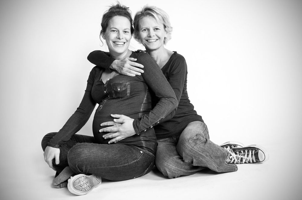 Black and white portrait series showing two people in casual attire sitting and embracing on a white background.