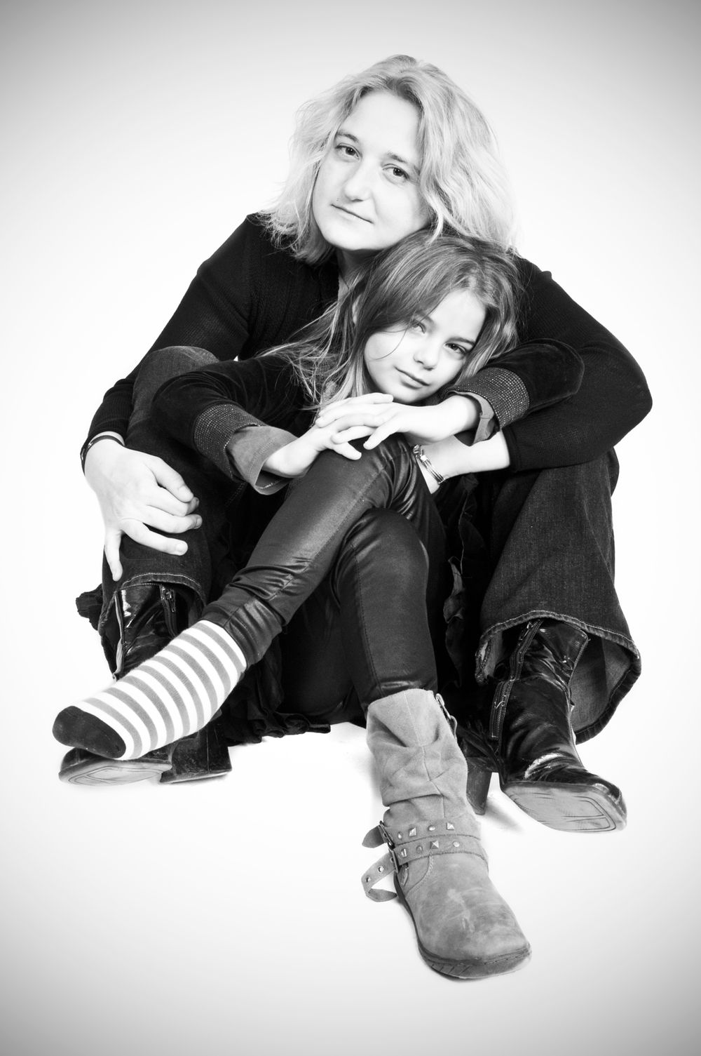 Black and white lifestyle portraits showing two people in casual poses wearing dark clothing.