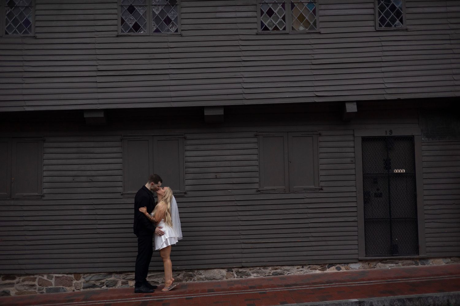 A series of black and white wedding photos showing couples embracing in various romantic poses against architectural backdrops.