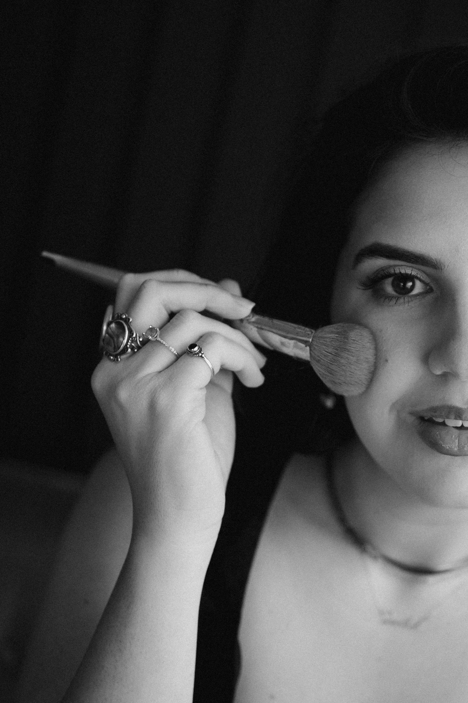 Black and white close-up portrait series showing artistic makeup application.