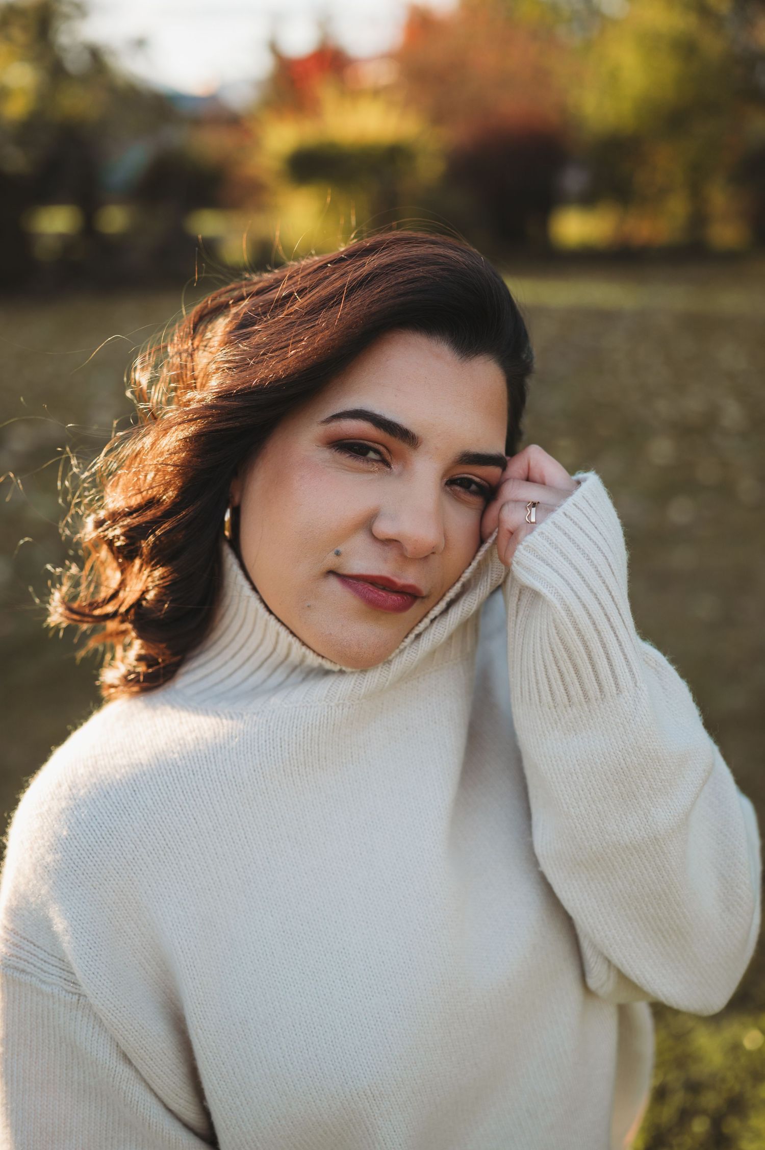 Outdoor autumn portrait series featuring person in cozy white turtleneck sweater.