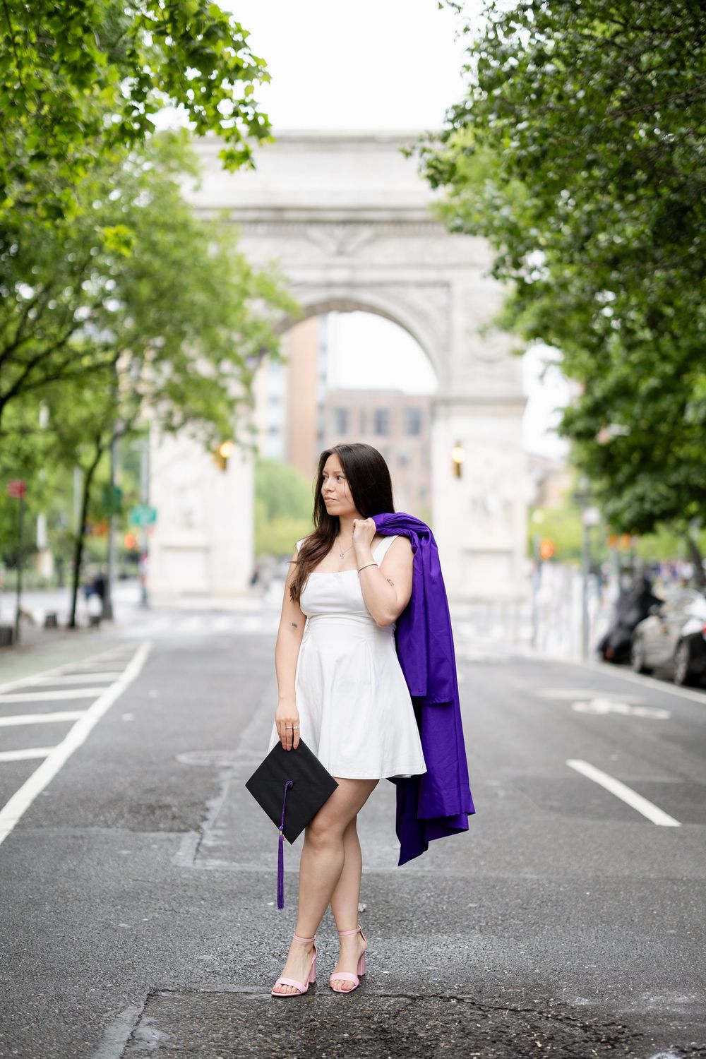 Fashion photoshoot on a city street with Washington Square Arch visible in the background.