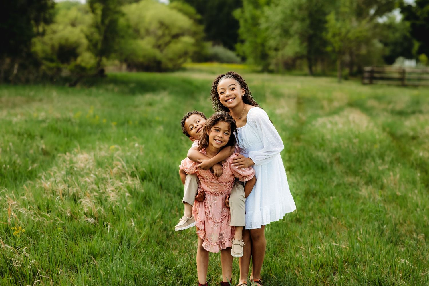 Children playing and laughing together in a lush green field on a sunny summer day.