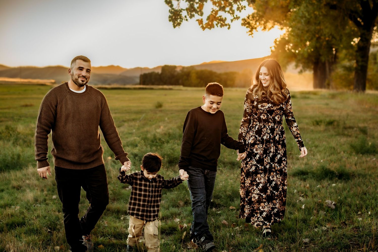 A series of sunset photos showing a family walking together in a golden field at dusk.
