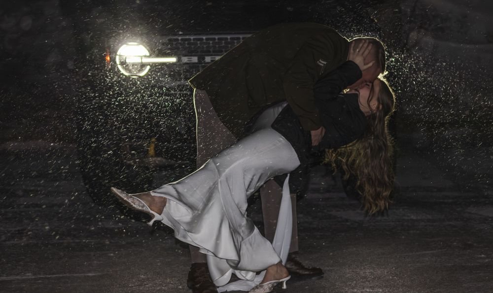 A person in white clothing performs a spinning dance move under dramatic nighttime lighting.