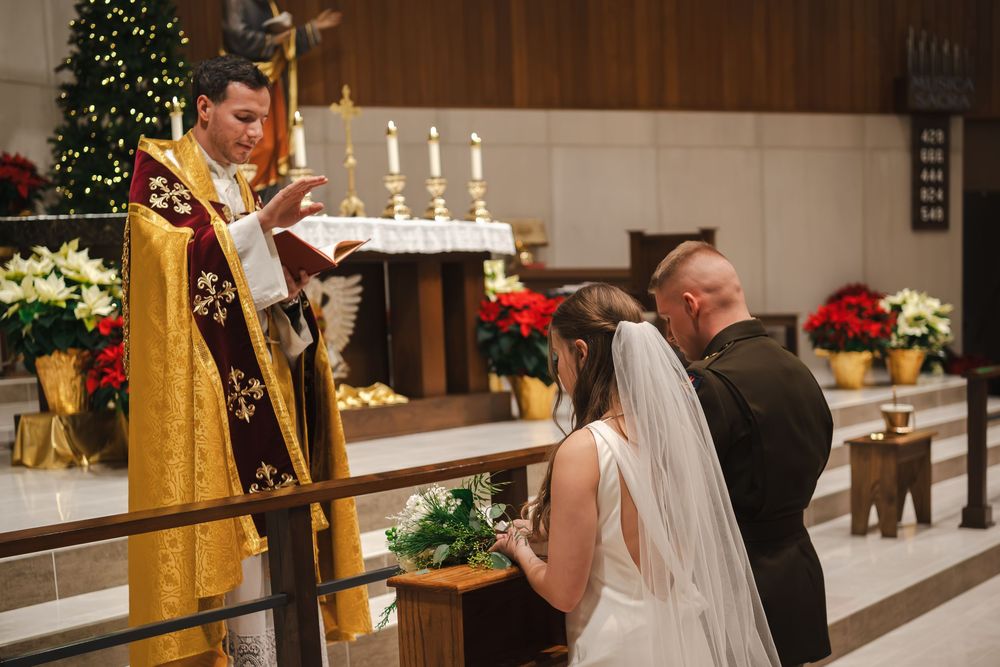 A wedding ceremony in a church decorated with Christmas trees and candles.