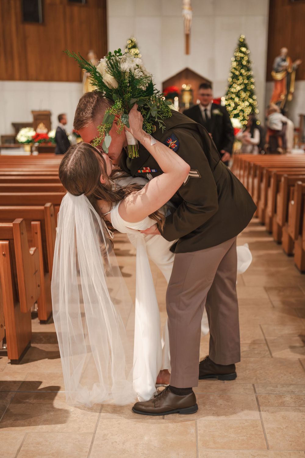 A sequence of wedding photos showing a couple's first kiss at the altar in a church with wooden pews and holiday decor.