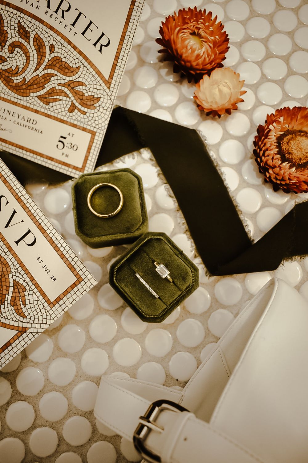 Wedding details with rings, dried flowers and vintage paper on textured background.