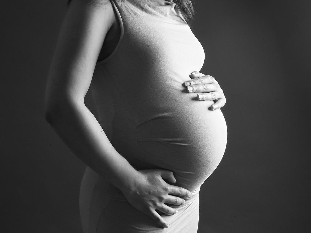 Black and white photo of a pregnant woman, captured by Abigail's studio in High Wycombe, showcasing maternity beauty.