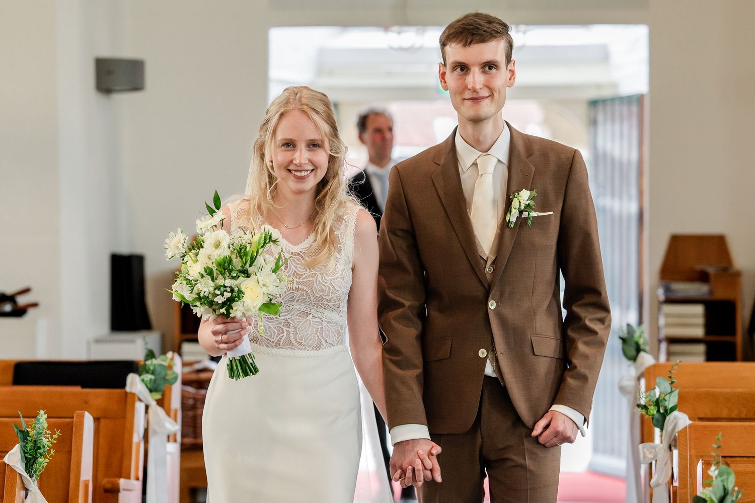 Bruidspaar loopt de kerk binnen naar de trouwdienst