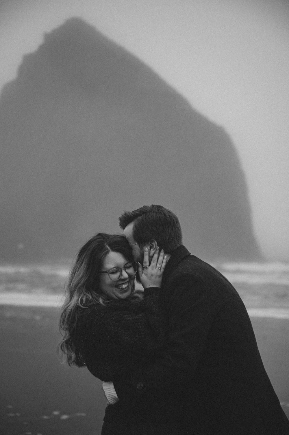 Dramatic black and white beach portraits with coastal cliffs in the background.