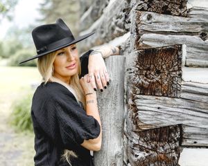 Artistic black and white portraits against weathered wood in rustic outdoor setting.