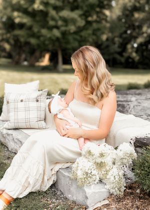 A tender moment on a stone bench surrounded by plush pillows and delicate white flowers.