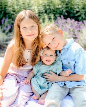 Siblings share sweet moments together outdoors on a sunny spring day.