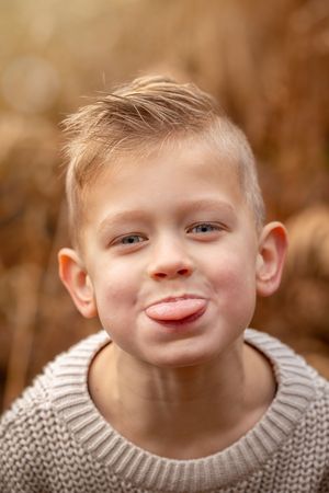 portret van een kind dat de tong uitsteekt. gefotografeerd buiten.