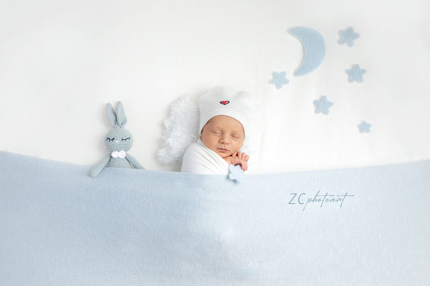 Artistically styled newborn photography session showing baby sleeping in soft beige tones and rustic textures.