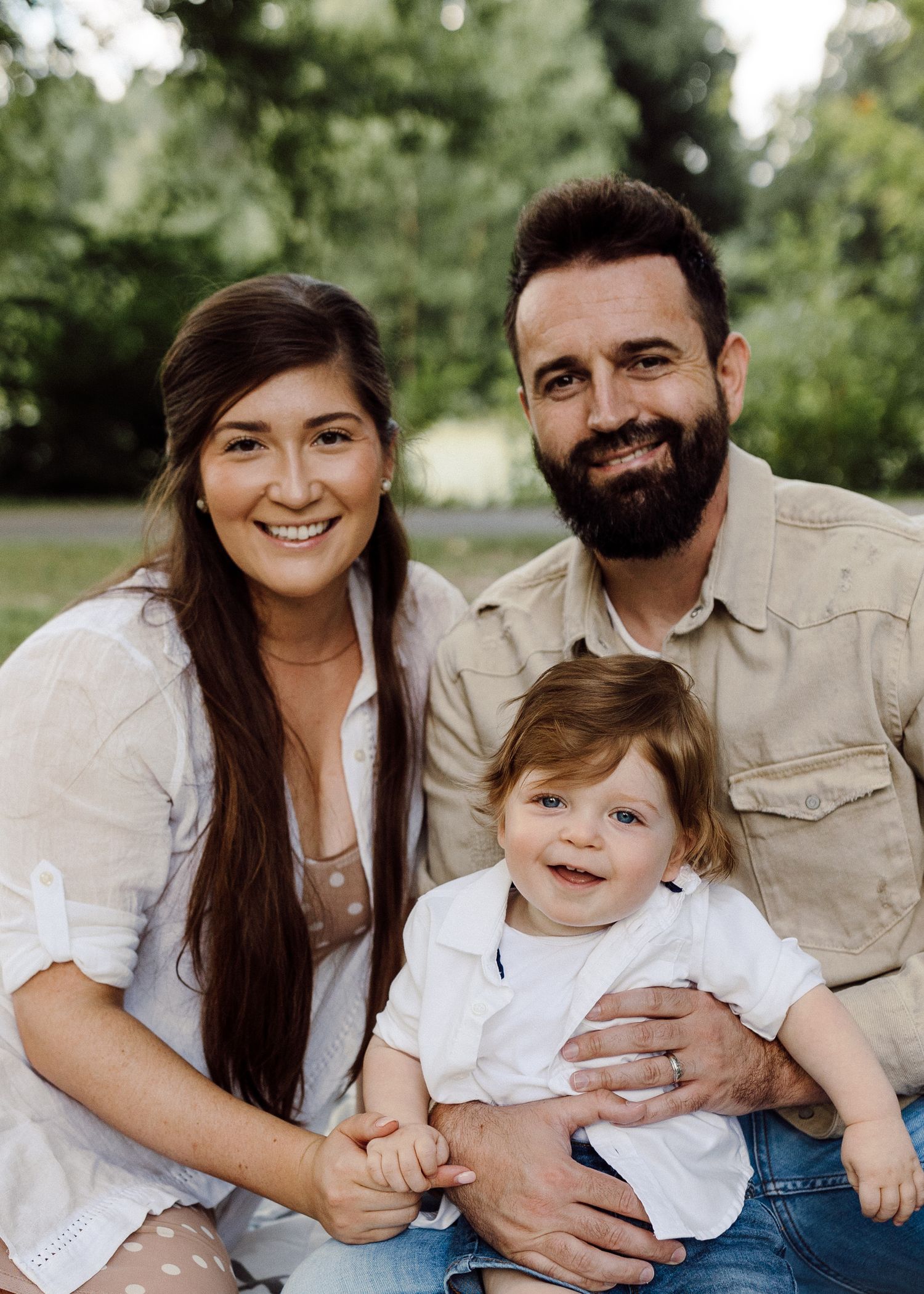 Candid family portrait outdoors showing joyful expressions and coordinated outfits.