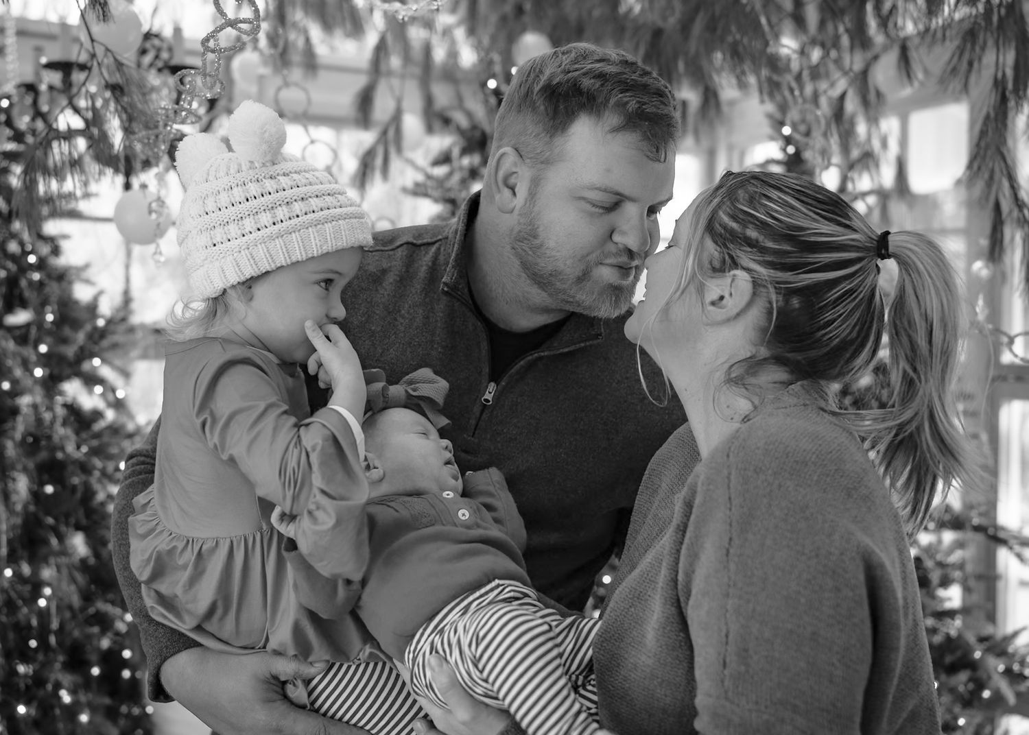 Black and white family photo series showing tender holiday moments and laughter.