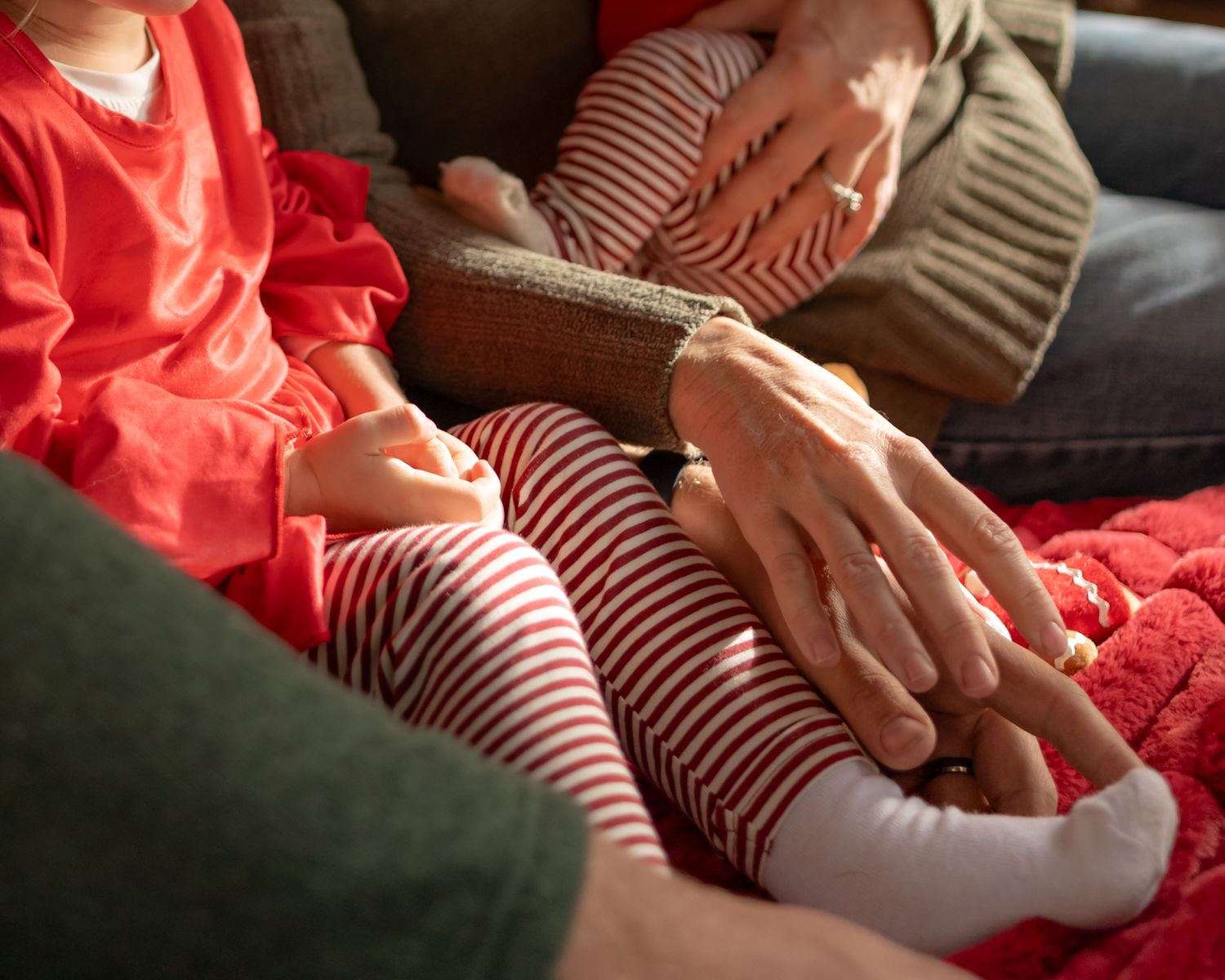 Close-up of hands and red and white striped holiday clothing details.