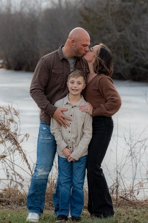 Candid family moment captured in winter setting with snow in background.