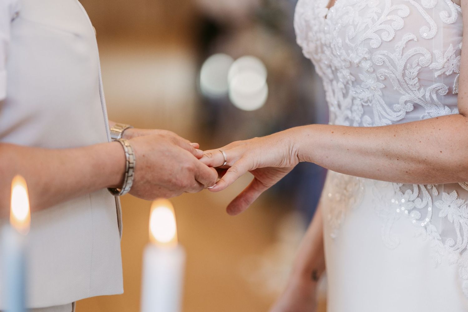 Close-up details of wedding rings and hands during an intimate ceremony.