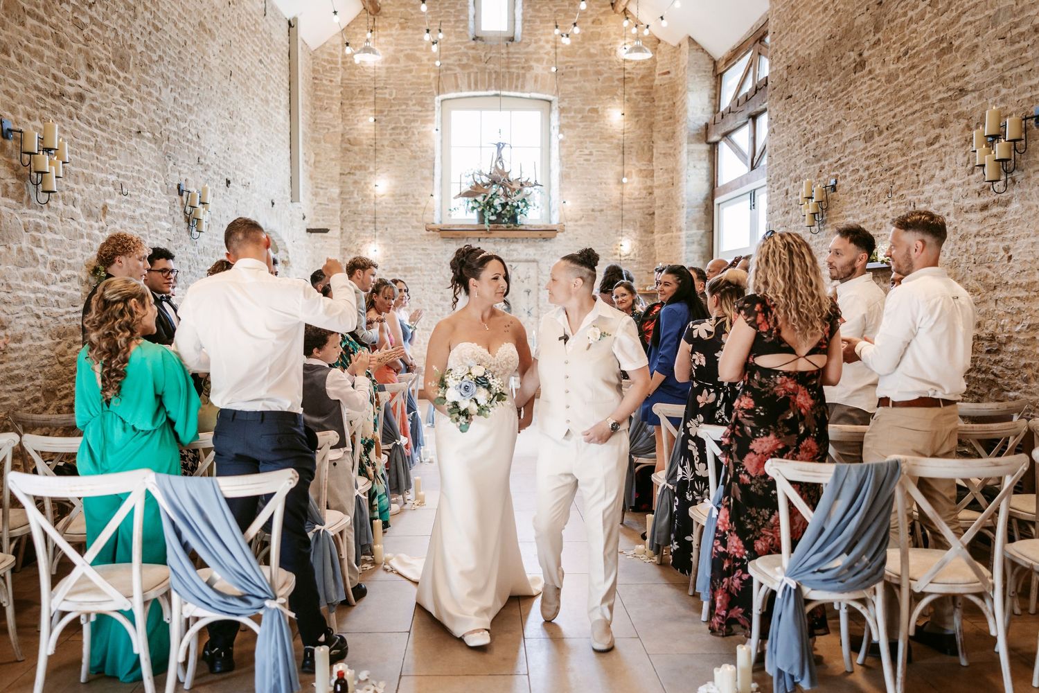 Wedding celebration in a rustic stone venue with exposed brick walls and elegant lighting.
