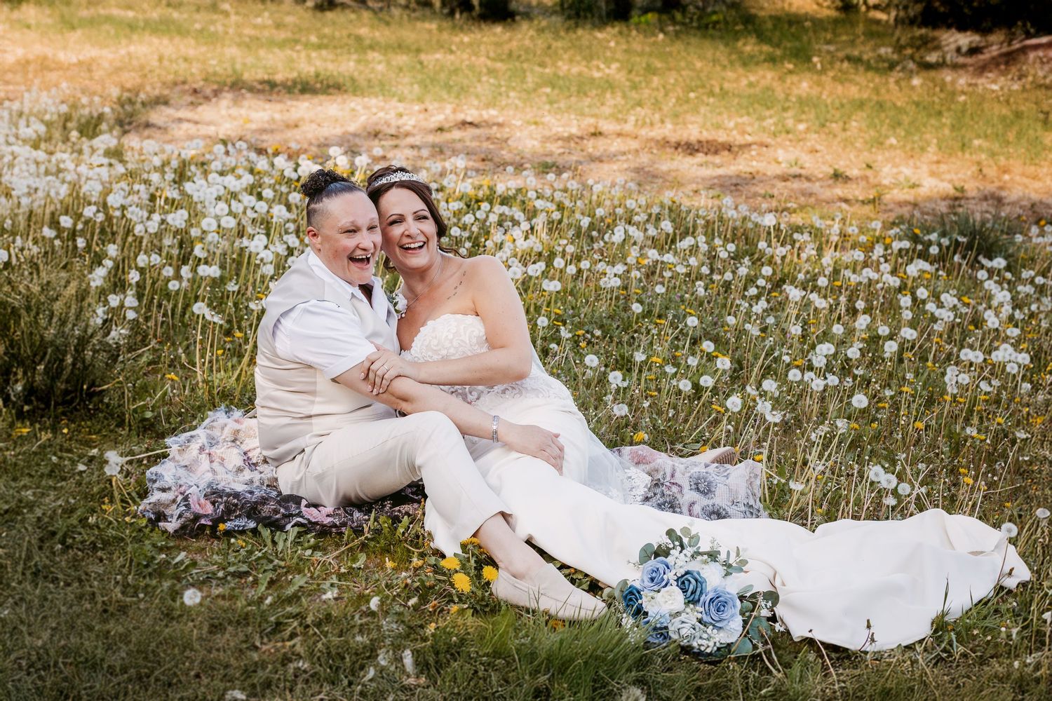 Couple relaxes in wildflower meadow during wedding photoshoot.