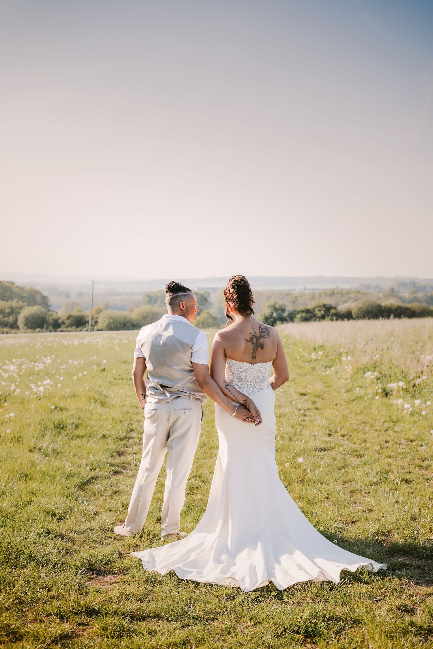 Sunset wedding portraits in a golden meadow with rolling hills in the background.
