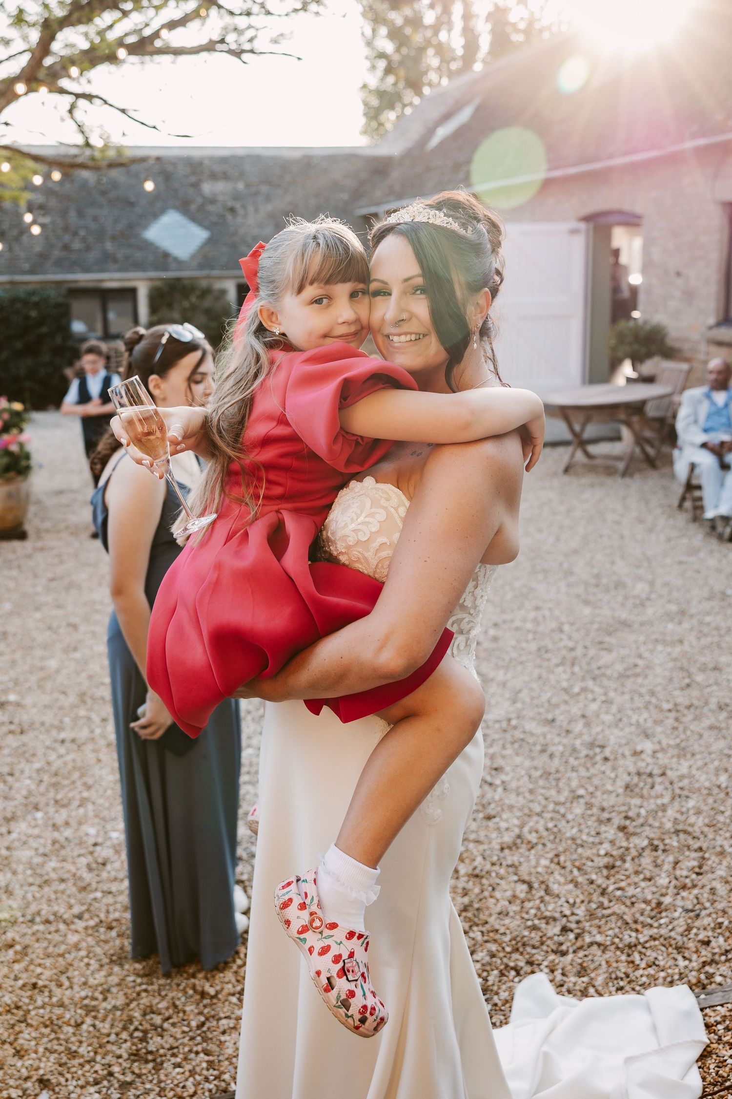 A series of candid moments showing two people embracing during an outdoor celebration on gravel ground at sunset.