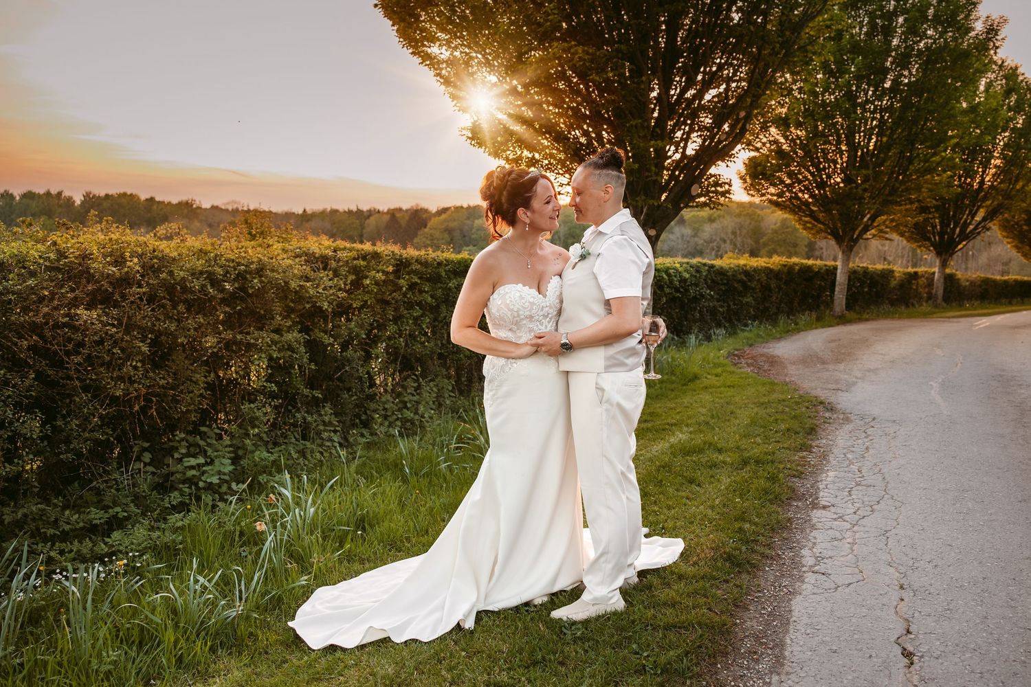 A romantic sunset wedding photo series showing a couple embracing on a winding country path at golden hour.