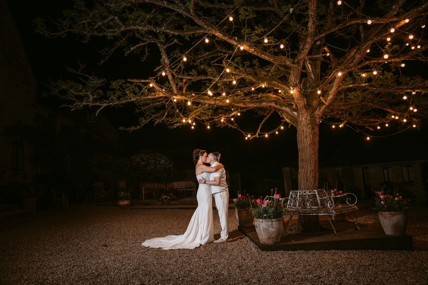 String lights illuminate a romantic outdoor wedding venue at dusk creating a magical ambiance.
