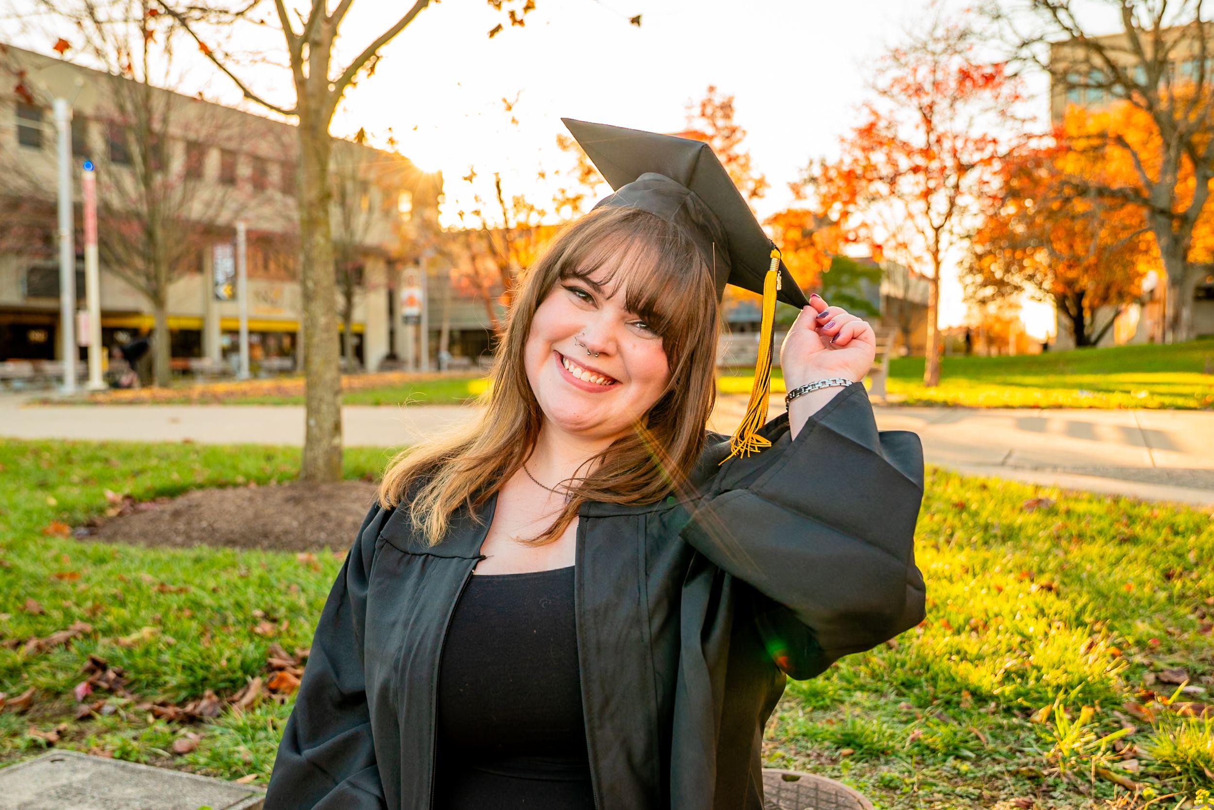 Autumn graduation photos with vibrant fall foliage in an outdoor setting.