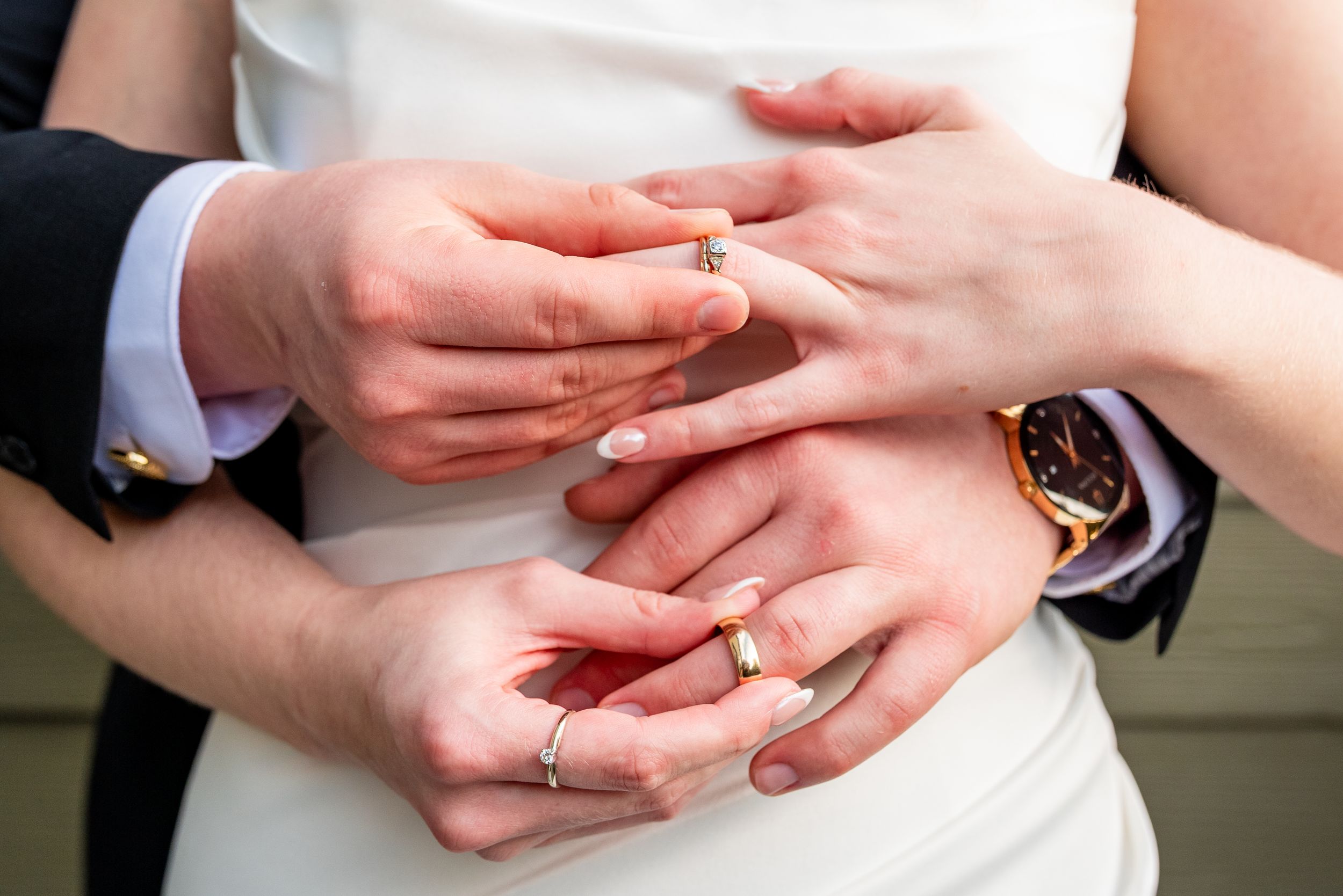 Close-up details of hands and wedding rings during an intimate ceremony.