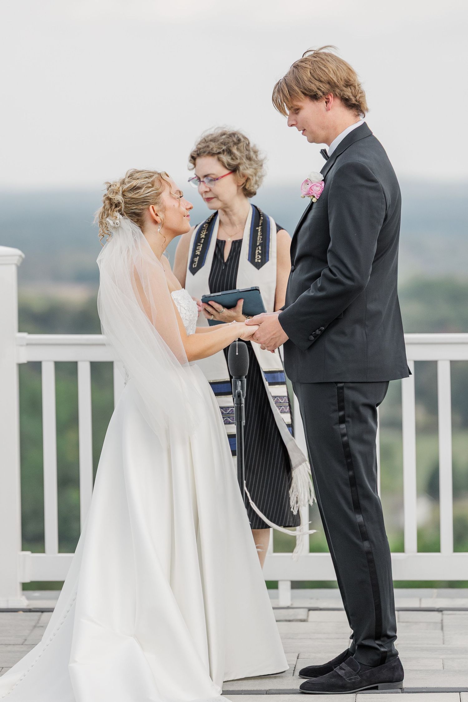 Intimate wedding ceremony moments on outdoor terrace with scenic backdrop.