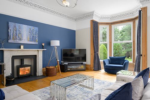 Collage of modern apartment interior photos showing blue accent walls, hardwood floors, and elegant crown molding details.