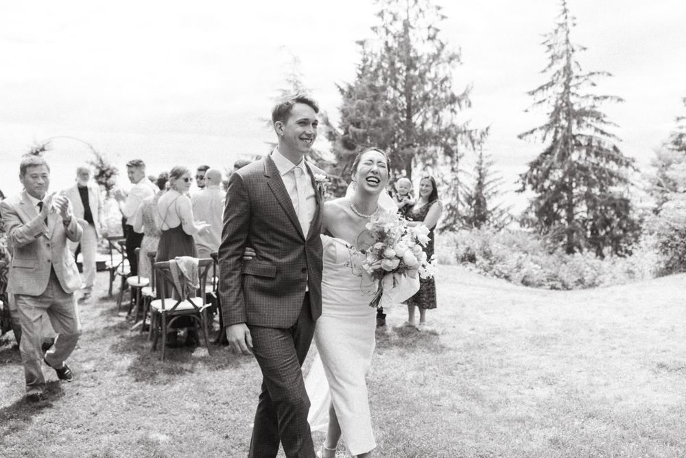 Black and white photo of wedding guests gathered outdoors for the ceremony.